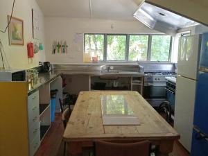 a kitchen with a wooden table in the middle of it at Eco Lodge Pakowhai in Hastings