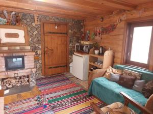 a log cabin living room with a couch and a fireplace at У Медовому Раю in Rostoka