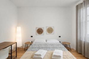 a white bedroom with a bed and a table at Affittacamere Villa Soria in Pesaro