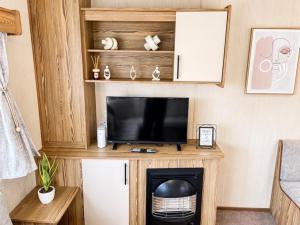 a living room with a tv and a fireplace at Golden Sands Getaways Weymouth in Wyke Regis
