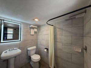 a bathroom with a toilet and a sink at Ponca Motel in Abilene