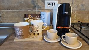 a counter with three coffee cups and a coffee maker at Salso Experience apartment in Salsomaggiore Terme