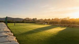 a tennis court with a net in the grass at La Casa di Nonna Iolanda in Gualdo Cattaneo