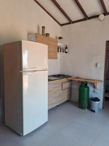 a kitchen with a white refrigerator and a table at Playa VICTORIA in Arboletes +16 photos