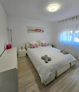 a white bedroom with a large bed with two pillows at DIAG Appartement 3 Chambres in Commequiers