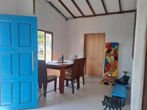 a dining room with a table and chairs and a blue door at Playa VICTORIA in Arboletes
