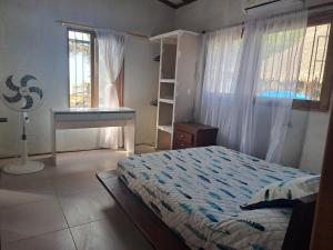 a bedroom with a bed and a desk and a window at Playa VICTORIA in Arboletes