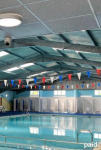 a large swimming pool with blue and red flags at B by the sea in Scratby