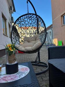 a swing chair sitting on top of a patio at Zeravica apartmani in Šid