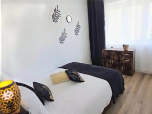 a bedroom with a bed and a clock on the wall at Escale 1 Spacieux avec CLIM in Tartas
