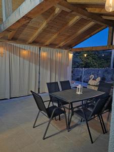 a patio with a table and chairs on a patio at Kuća za odmor Neva in Nečujam
