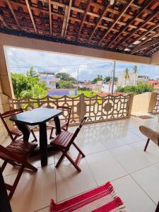 eine Terrasse mit Tisch und Stühlen auf einem Balkon in der Unterkunft Pousada Aconchego Sol e Mar in Maragogi