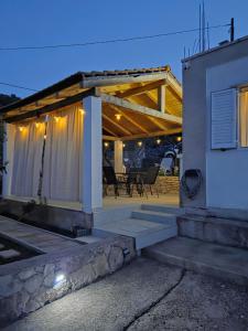 a house with a covered porch with a patio at Kuća za odmor Neva in Nečujam