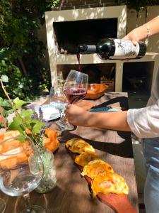 a person is pouring a glass of wine on a table at Rincón Las Hiedras in Chacras de Coria
