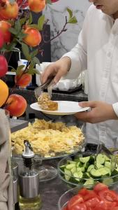 a chef is preparing food on a buffet at Art Royal in Tashkent