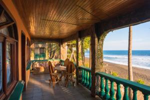 a porch with a table and chairs on the beach at Host Company Jaco Luxury in Jacó