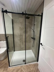 a shower with a glass door in a bathroom at Modern Two- bedroomed flat in Wick, Caithness in Wick +8 photos