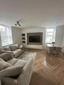a living room with a couch and a television at Modern Two- bedroomed flat in Wick, Caithness in Wick