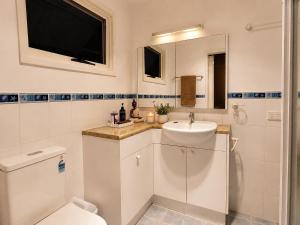 a white bathroom with a sink and a toilet at Hidden Gem in the CBD in Coffs Harbour +13 photos