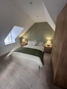 a attic bedroom with a bed and a window at Modern Two- bedroomed flat in Wick, Caithness in Wick