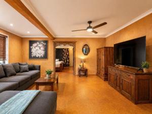 a living room with a couch and a flat screen tv at Hidden Gem in the CBD in Coffs Harbour