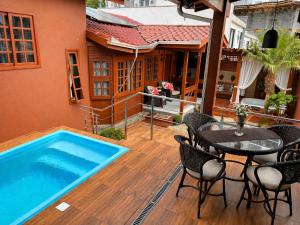 a patio with a table and a swimming pool at Casa com Piscina e Jacuzzi, Próxima da Praia Brava in Itajaí