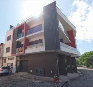 a building with a person sitting in front of it at Miles Dreams Laginha in Mindelo +2 photos