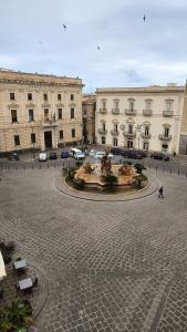 a large building with a fountain in the middle of a courtyard at Archimede29 in Syracuse