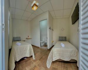 a room with two beds and a bathroom at Belo Hotel in Ribas do Rio Pardo