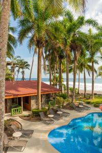 a resort with a swimming pool and palm trees at Host Company Jaco Luxury in Jacó