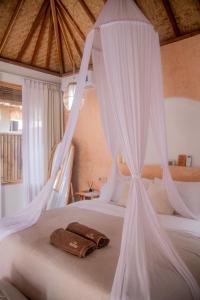 a bedroom with a bed with white mosquito nets at Villa Nyantara - Private tropical villa in Gili Islands