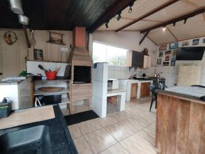 a large kitchen with wooden cabinets and a counter top at Chácara Caminho do Rio in Morretes