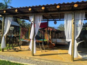a playground with a pavilion and a swing set at Chácara Caminho do Rio in Morretes