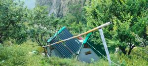 a house sitting in the middle of a field at Ambar Cottage in Kullu Manali