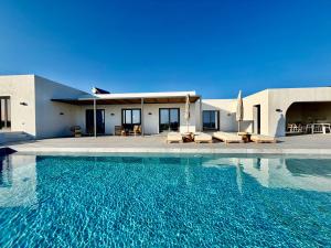 a house with a swimming pool in front of a house at Faragas Hill Euphoria Villa in Angairiá