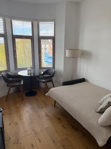 a bedroom with a bed and a table and chairs at Top Floor West End Flat - 3-Min Walk to Subway - Park Views in Glasgow