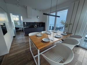 a dining room with a table and white chairs at LakeView 59 Lemon Resort Spa in Gródek Nad Dunajcem