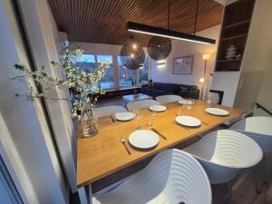 a dining room table with white plates and chairs at LakeView 59 Lemon Resort Spa in Gródek Nad Dunajcem