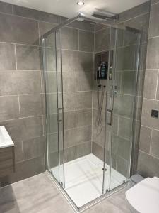 a shower with a glass door in a bathroom at Top Floor West End Flat - 3-Min Walk to Subway - Park Views in Glasgow +9 photos