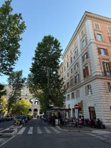 a street in a city with a building and a tree at Colosseum's Custodian - Apartment 115 m2 in Rome