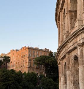 an ancient building with a building in the background at Colosseum's Custodian - Apartment 115 m2 in Rome