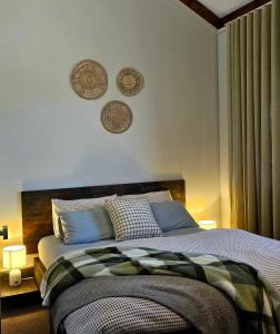 a bedroom with a bed and two plates on the wall at 12 Apostles Cottages - Tullarook in Princetown +2 photos