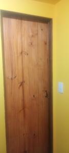 a wooden door in a room with a yellow wall at Amapolas monoambiente in El Bolsón