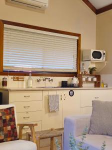 a kitchen with a couch and a sink and a window at 12 Apostles Cottages - Tullarook in Princetown