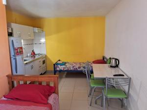 a small kitchen with a table and a bed in it at Complejo FE LE SA in Las Grutas