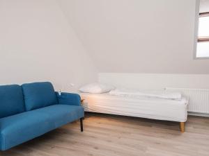 a bed and a blue couch in a room at 2 person holiday home in Ringkøbing in Ringkøbing