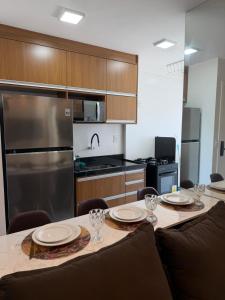 a kitchen with a table with plates and glasses on it at Apartamento Novo Infinity in Vila Velha