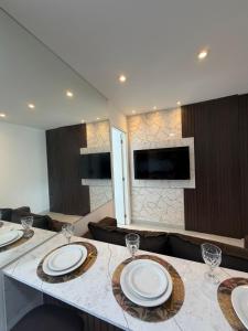 a living room with a table with plates and wine glasses at Apartamento Novo Infinity in Vila Velha +8 photos
