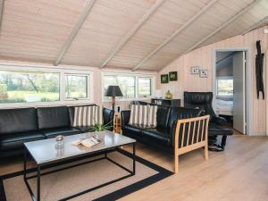 a living room with black leather furniture and a table at 8 person holiday home in Sydals in Neder Lysabild