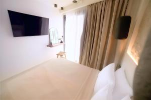 a bedroom with a bed and a window at ŌMNIMI Signature Living in Skala Potamias